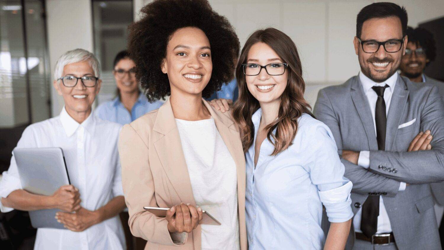 Group of diverse professionals smiling confidently in an office setting, representing students in English classes in Mexico